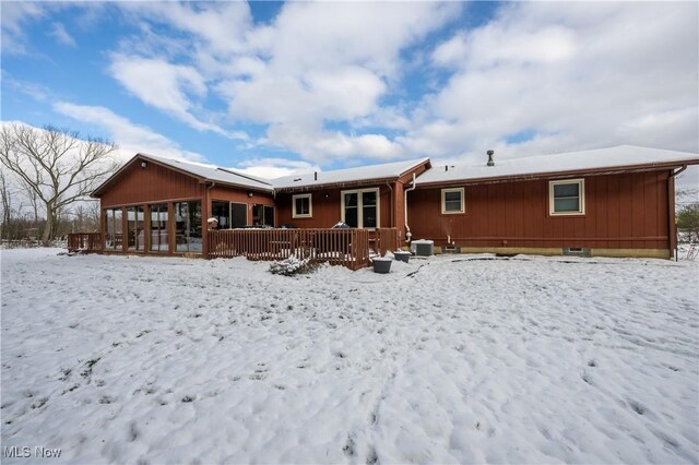 snow covered property with a deck