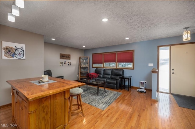 living room with light wood-type flooring and a textured ceiling