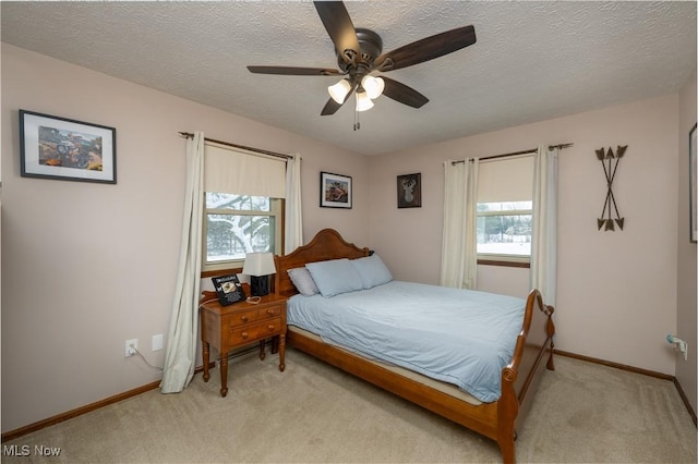 carpeted bedroom with ceiling fan and a textured ceiling