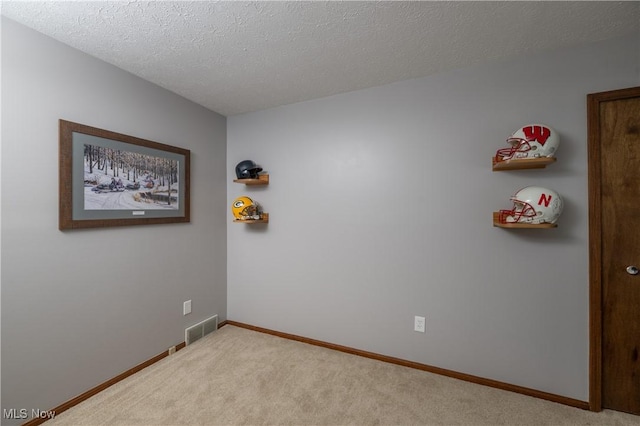 carpeted spare room featuring a textured ceiling