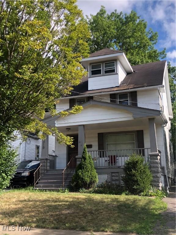 view of front of house featuring covered porch and a front yard