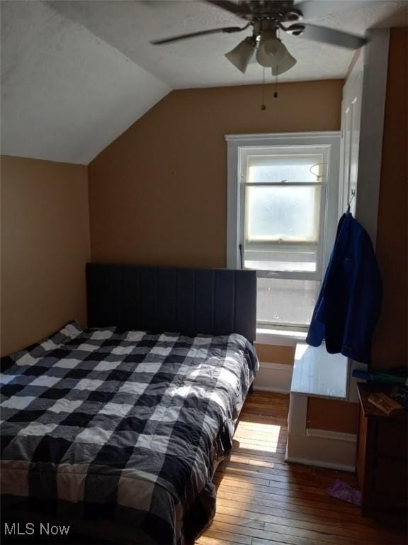 bedroom featuring hardwood / wood-style flooring, ceiling fan, and lofted ceiling