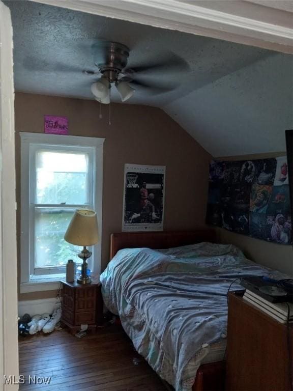 bedroom with a textured ceiling, multiple windows, ceiling fan, and lofted ceiling