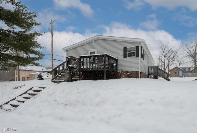 snow covered house with a deck