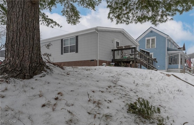 snow covered property with a wooden deck