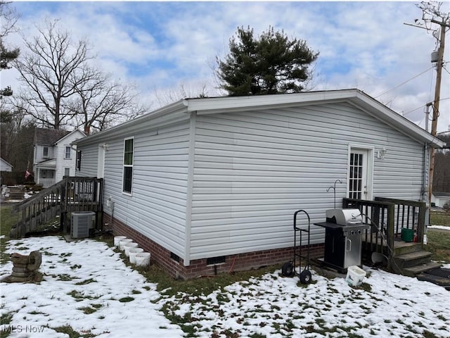 view of snowy exterior featuring central AC