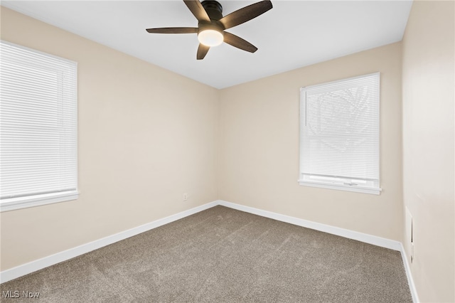 unfurnished room with ceiling fan and carpet