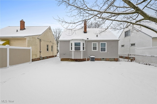 snow covered back of property with central AC unit