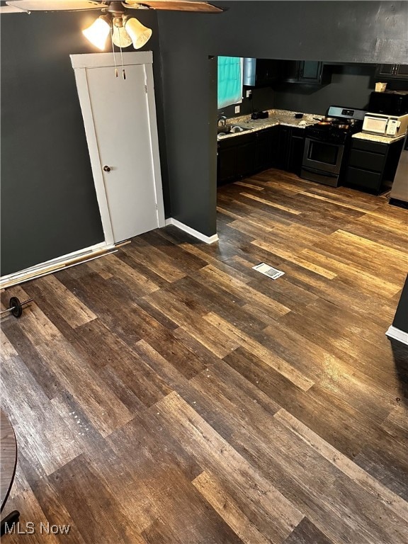 kitchen featuring dark hardwood / wood-style flooring, ceiling fan, and stainless steel range