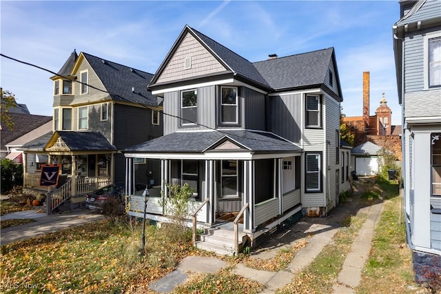 6114 W Clinton Ave, Cleveland, OH 44102 - view of front of home with board and batten siding, covered porch, roof with shingles, and an outdoor structure