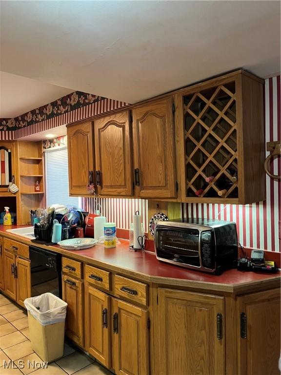 kitchen with a toaster, dishwasher, light tile patterned floors, brown cabinetry, and open shelves