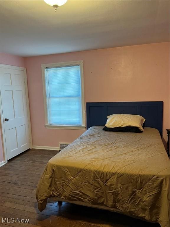 bedroom with visible vents, baseboards, and dark wood-style flooring