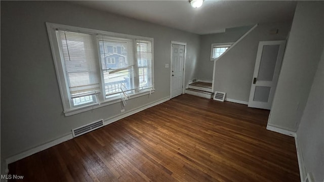 interior space with plenty of natural light and dark hardwood / wood-style floors