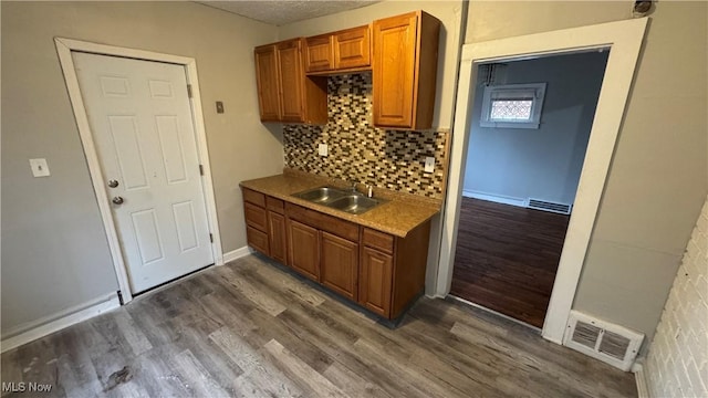 kitchen featuring backsplash, dark hardwood / wood-style flooring, and sink