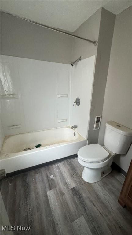 bathroom featuring shower / bath combination, wood-type flooring, and toilet