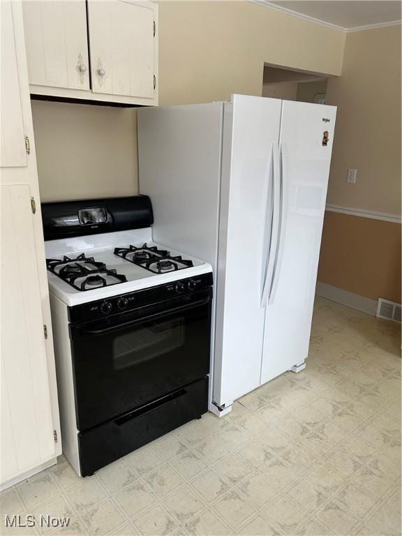 kitchen featuring white cabinets, white appliances, and crown molding