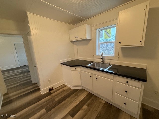 kitchen featuring white cabinetry, sink, and dark hardwood / wood-style floors