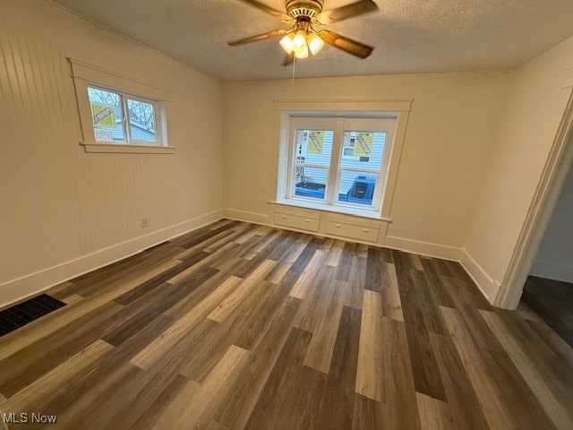 unfurnished room featuring a textured ceiling, dark hardwood / wood-style floors, and ceiling fan