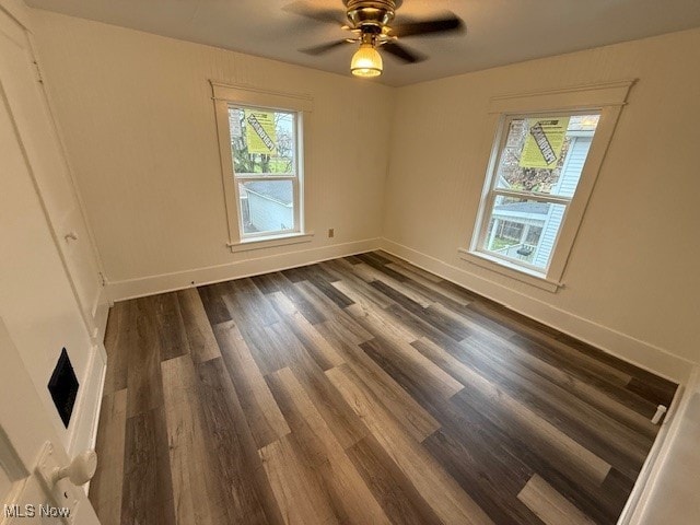 spare room with ceiling fan and dark hardwood / wood-style flooring