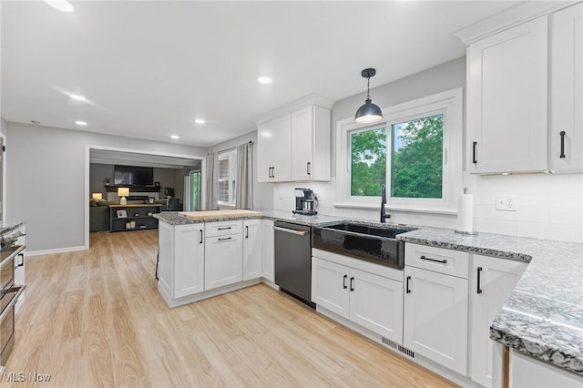 kitchen with kitchen peninsula, light wood-type flooring, decorative light fixtures, dishwasher, and white cabinetry