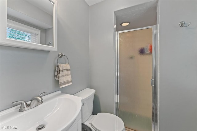 bathroom with vanity, toilet, and a shower with shower door