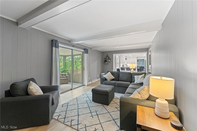 living room featuring beamed ceiling, light hardwood / wood-style flooring, and crown molding