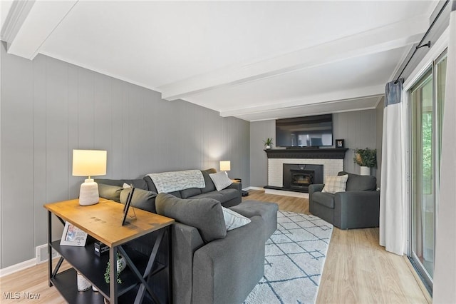 living room with beamed ceiling and light wood-type flooring