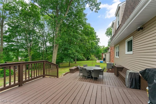 wooden deck featuring a lawn and central AC