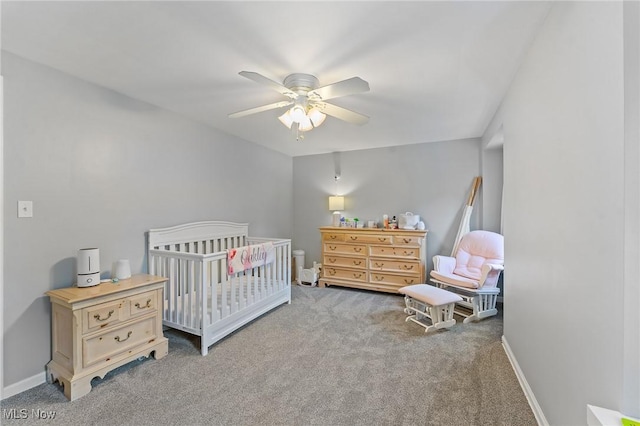 bedroom with ceiling fan, carpet floors, and a nursery area