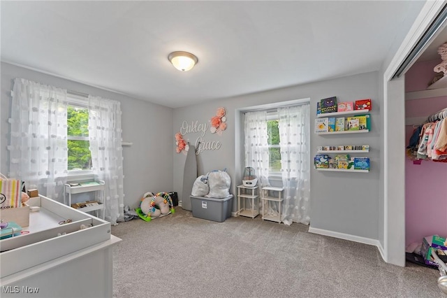 bedroom with light colored carpet and multiple windows