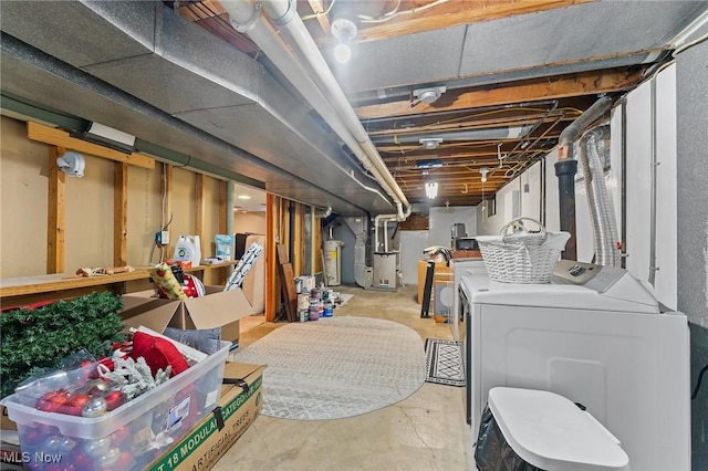 basement with heating unit, water heater, and washer and clothes dryer