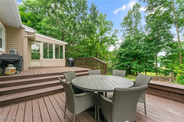 wooden deck featuring a sunroom and area for grilling