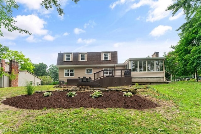 rear view of house with a sunroom, a yard, and a wooden deck