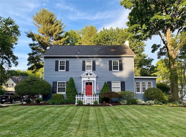 colonial home featuring a front lawn