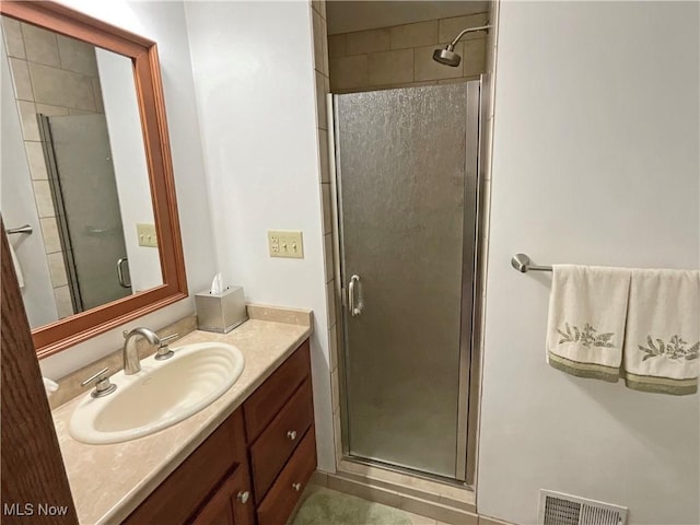 bathroom featuring vanity and a shower with door