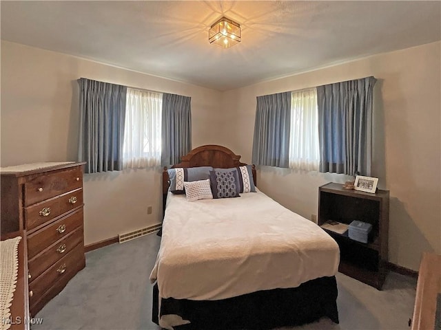 bedroom with light colored carpet and a baseboard radiator