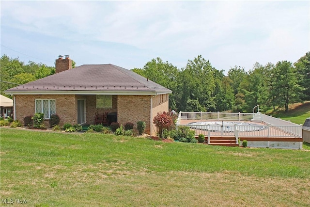 rear view of property with a yard and a wooden deck