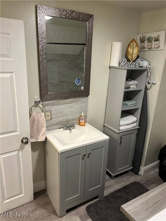 bathroom featuring vanity and backsplash