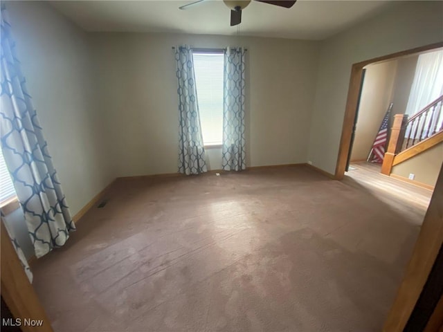 spare room featuring ceiling fan, plenty of natural light, and carpet