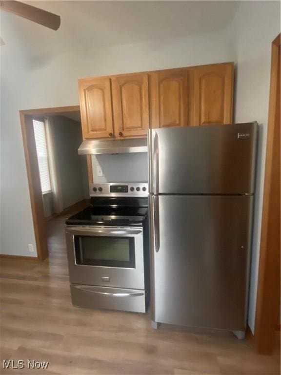 kitchen featuring ceiling fan, stainless steel appliances, and light hardwood / wood-style floors