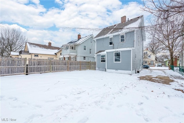 view of snow covered rear of property