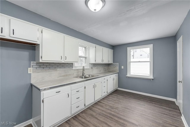 kitchen with backsplash, sink, white cabinets, and plenty of natural light