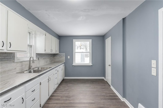 kitchen with backsplash, dark hardwood / wood-style flooring, white cabinetry, and sink