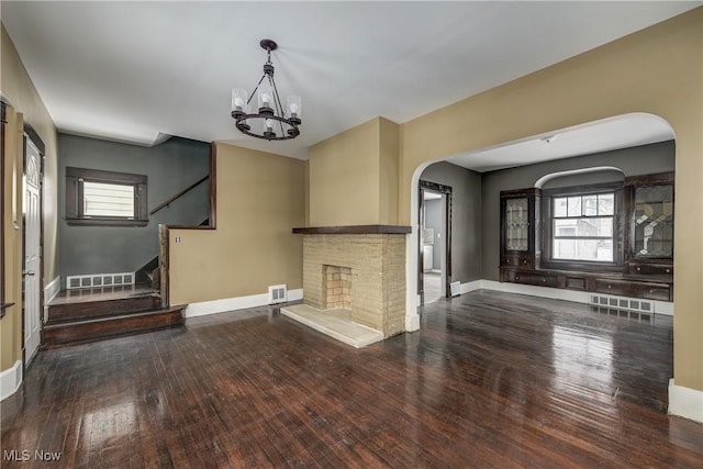 unfurnished living room with hardwood / wood-style floors and a notable chandelier