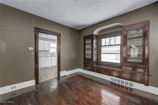 unfurnished room featuring wood-type flooring and sink