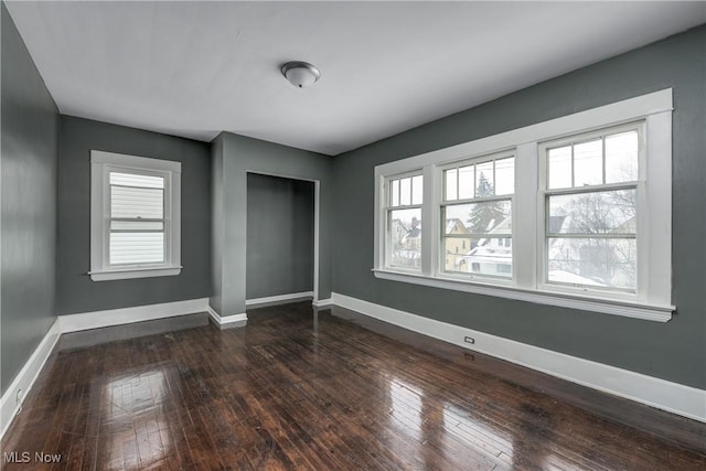 unfurnished bedroom with dark wood-type flooring