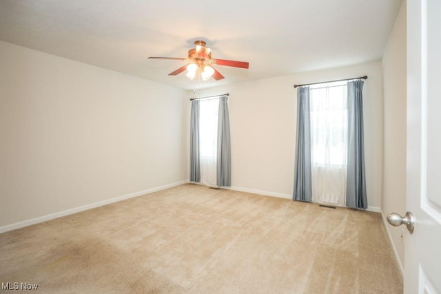 carpeted spare room with ceiling fan