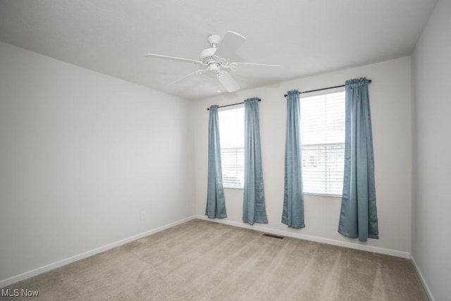 unfurnished room featuring ceiling fan and light colored carpet