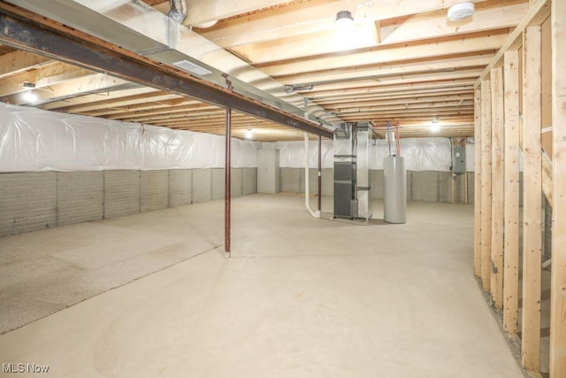 basement with heating unit, electric panel, and water heater