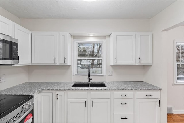 kitchen featuring white cabinets, light wood-type flooring, sink, and stainless steel appliances